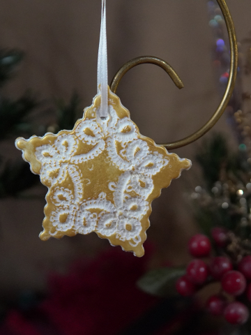 Deep gold star ornament with impressed tatted-lace design
