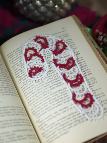 Red and white lace candy cane bookmark photographed on book pages with gentle Ch