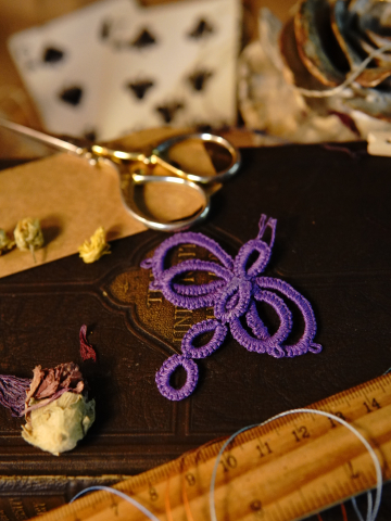 Close-up of handmade tatted dragonfly on book cover