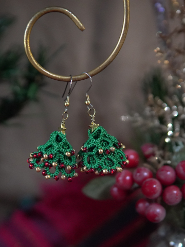 Festive tatted tree earrings displayed with holiday background