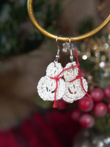 Simple white tatted snowman earrings shown in festive holiday décor