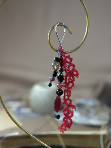 Close-up of red lace keychain with dark gemstone drops
