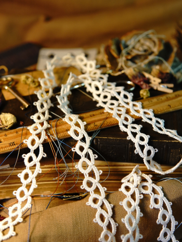 White tatted loop lace trim draped over vintage books and ruler