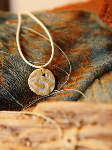 Ivory Impressions – Small Gold-Rubbed Round Pendant (White Cord)